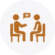 Two stylized figures seated across from each other at a small table, one gesturing as if speaking, the other listening, symbolizing a conversation.